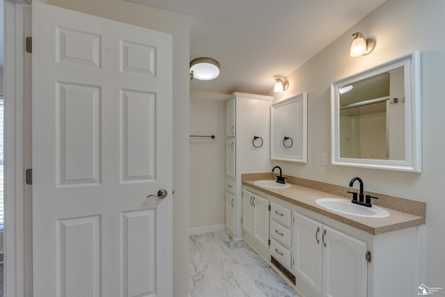 bathroom with double vanity, baseboards, marble finish floor, and a sink