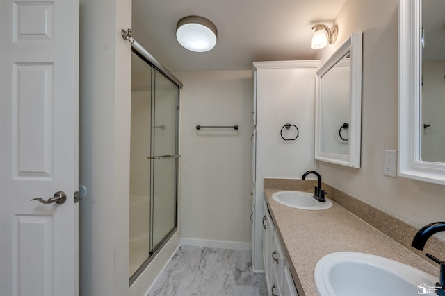 bathroom featuring double vanity, a stall shower, marble finish floor, and a sink