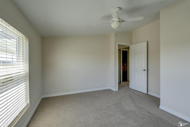 unfurnished room featuring baseboards, ceiling fan, and light colored carpet