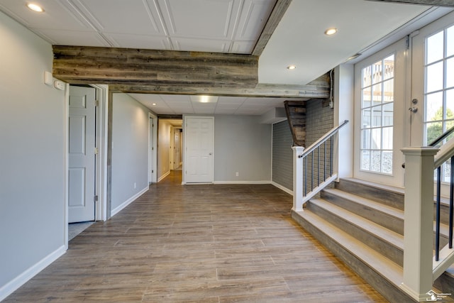 below grade area featuring recessed lighting, stairs, wood finished floors, and baseboards