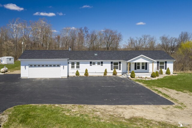 ranch-style house featuring a garage, driveway, and a front yard