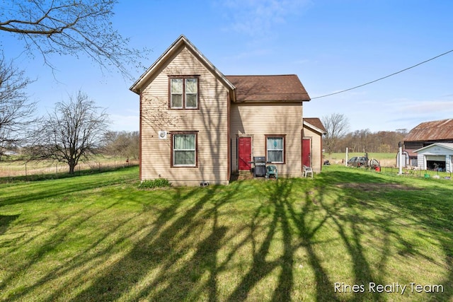 rear view of property featuring a lawn