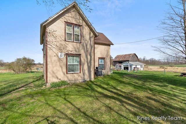 back of property featuring a yard