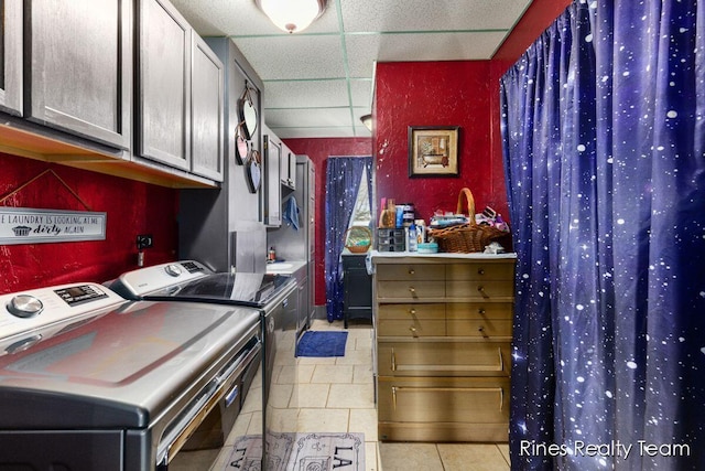 laundry room featuring cabinet space, separate washer and dryer, and light tile patterned floors