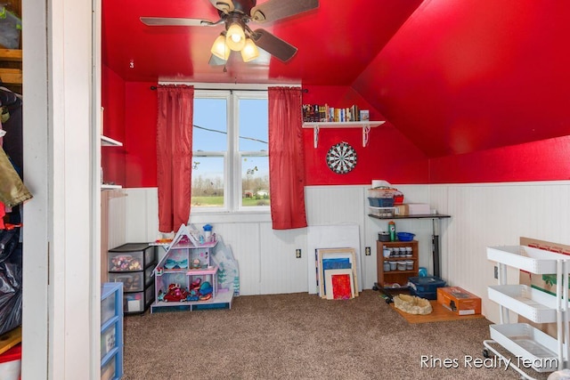 rec room featuring carpet flooring, ceiling fan, lofted ceiling, and a wainscoted wall