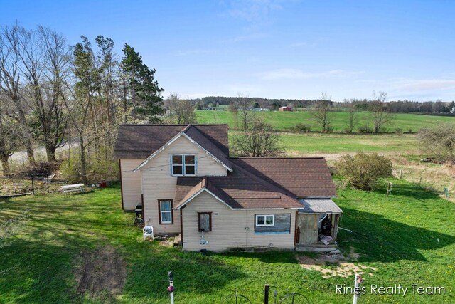 view of front of property with a shingled roof and a front lawn