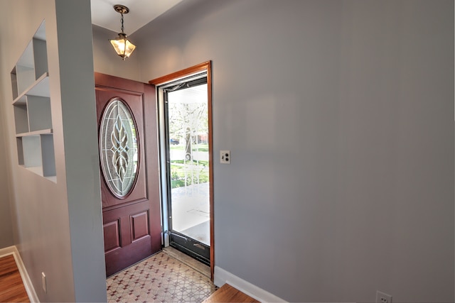 foyer with baseboards and light floors