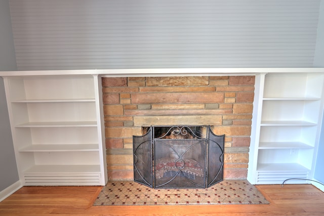 room details with a stone fireplace and wood finished floors
