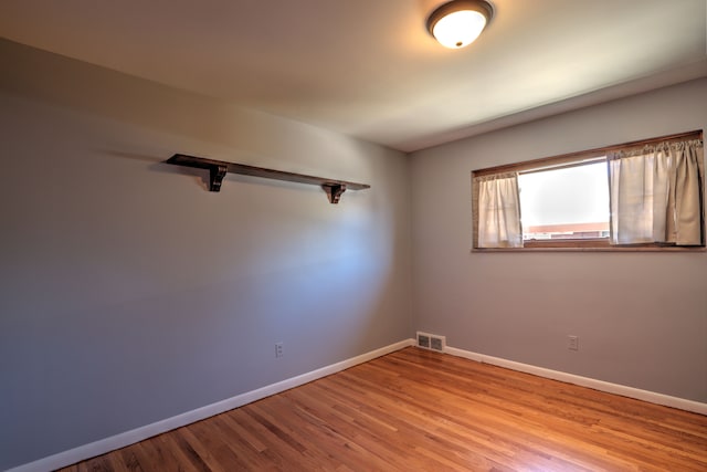 unfurnished room with baseboards, visible vents, and light wood-type flooring