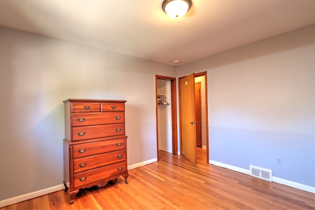 bedroom featuring visible vents, light wood-style flooring, and baseboards