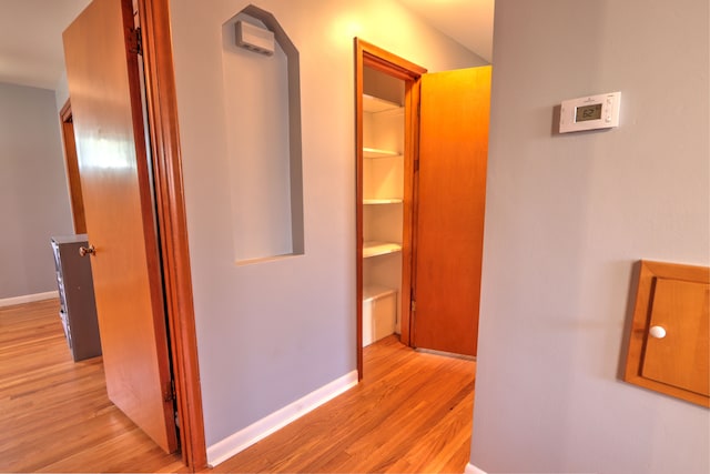 hallway featuring baseboards and light wood finished floors