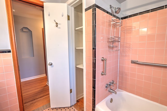 full bathroom featuring wood finished floors and shower / bathtub combination