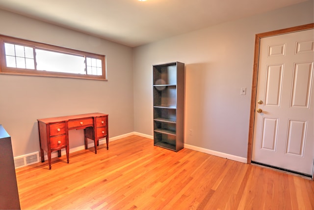 unfurnished office featuring baseboards, visible vents, and light wood-style floors