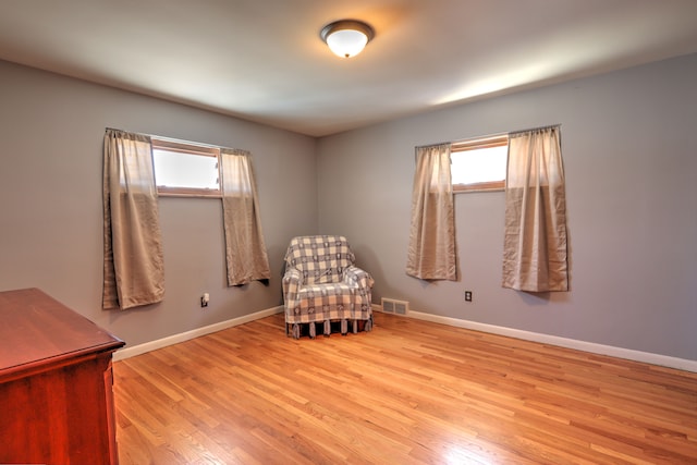 living area with plenty of natural light, wood finished floors, and visible vents