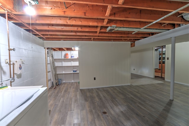 unfinished basement with baseboards, washer / dryer, and wood finished floors