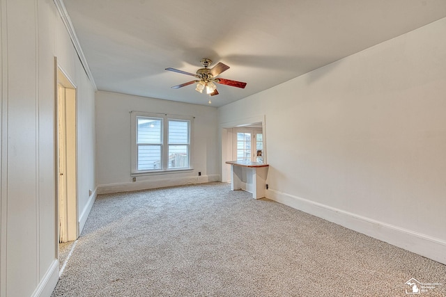 unfurnished bedroom featuring light colored carpet, ceiling fan, and baseboards