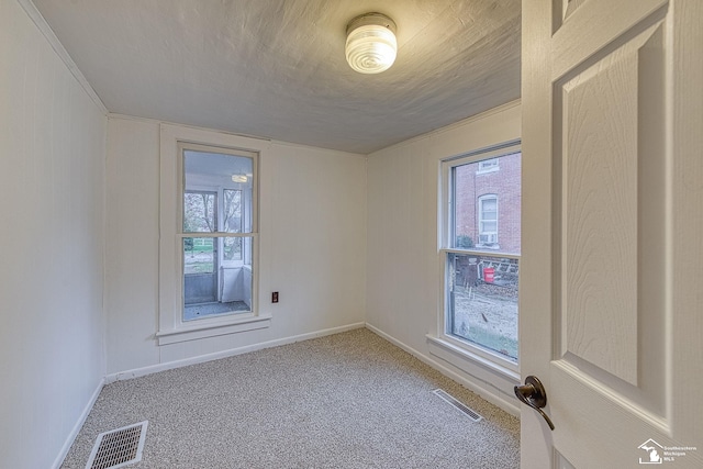 spare room featuring visible vents, carpet floors, and baseboards