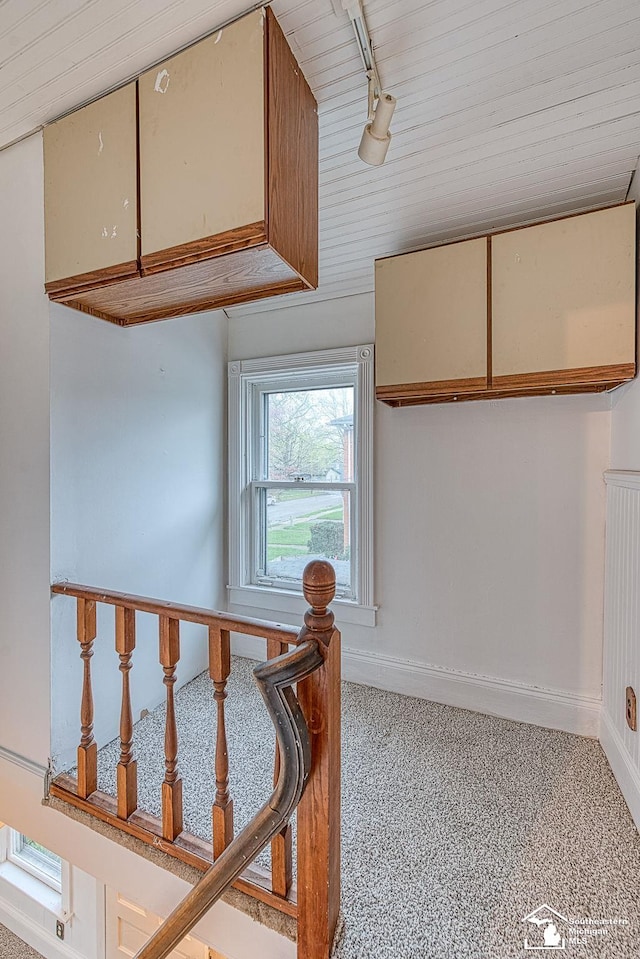 stairs featuring baseboards, wooden ceiling, and speckled floor
