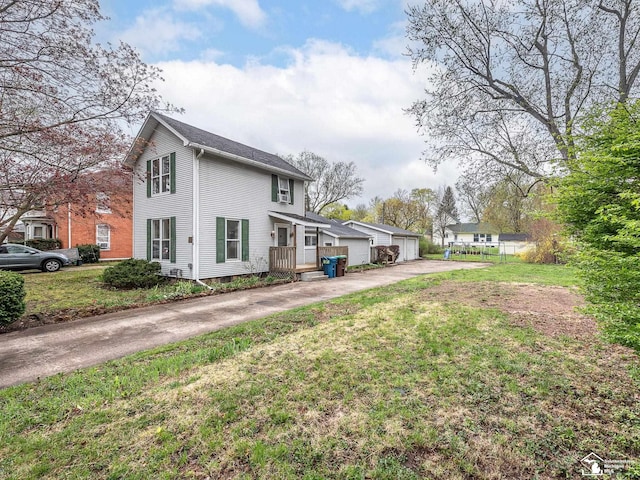 view of home's exterior with a detached garage and a lawn