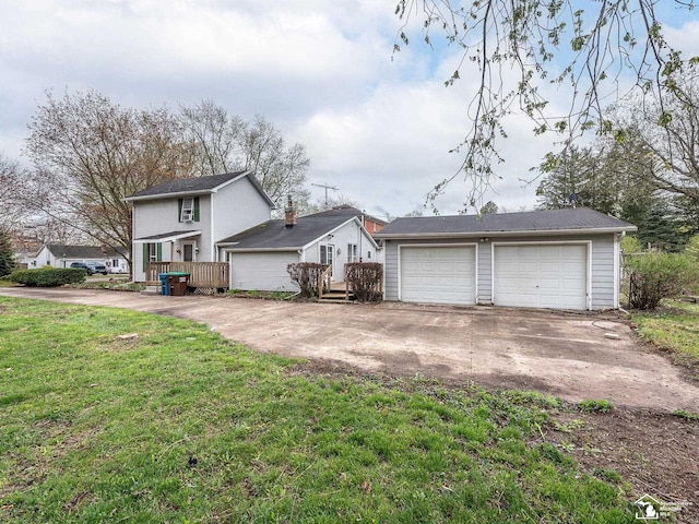 exterior space with a front yard, an outbuilding, and a garage