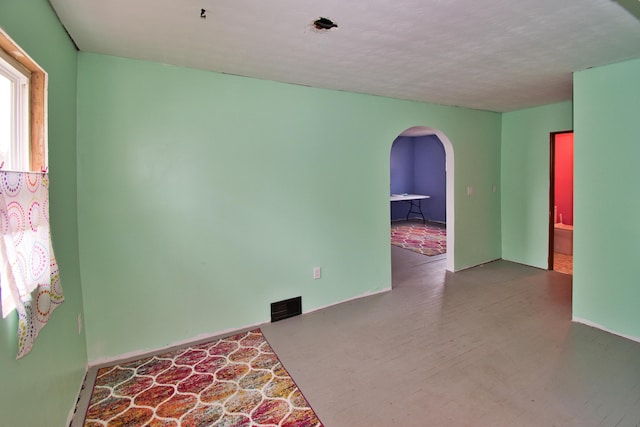empty room with arched walkways and visible vents