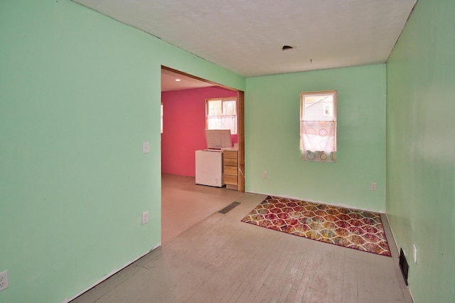 spare room featuring visible vents and hardwood / wood-style floors