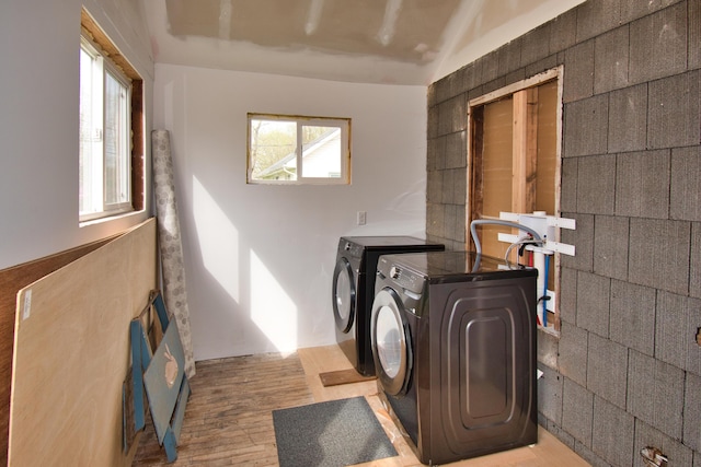 laundry room with washing machine and dryer and light wood-style floors