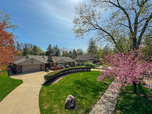 ranch-style house with an attached garage, brick siding, a front yard, and concrete driveway