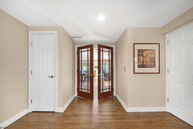 foyer with baseboards, french doors, wood finished floors, and visible vents