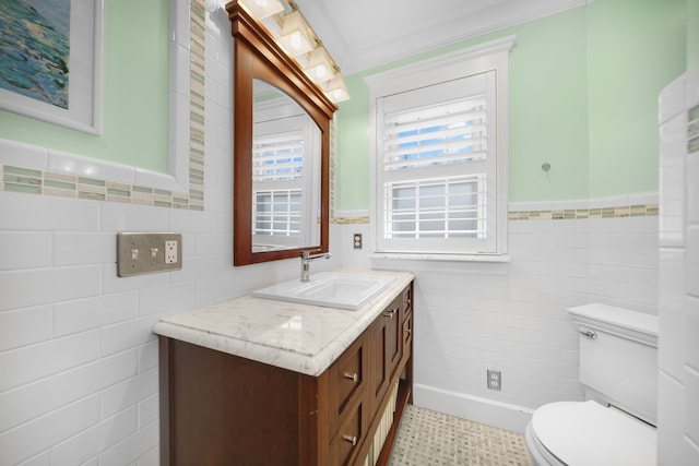half bath featuring crown molding, vanity, toilet, a wainscoted wall, and tile walls