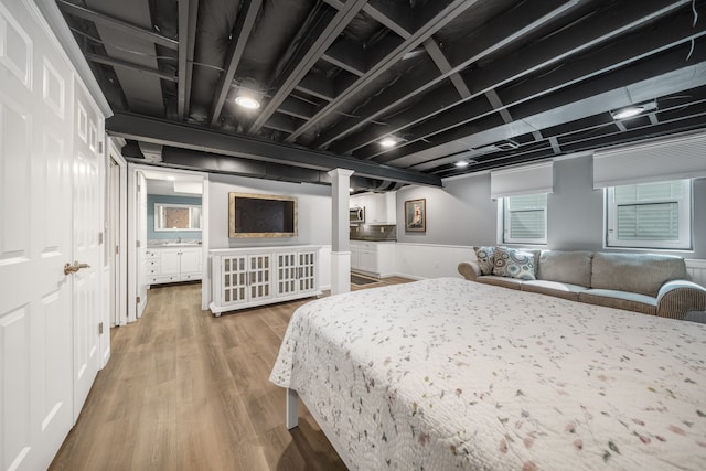 bedroom with a sink and wood finished floors