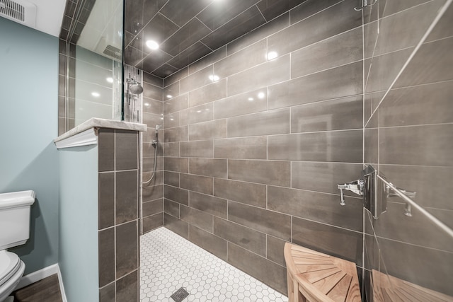 bathroom with a walk in shower, toilet, and visible vents