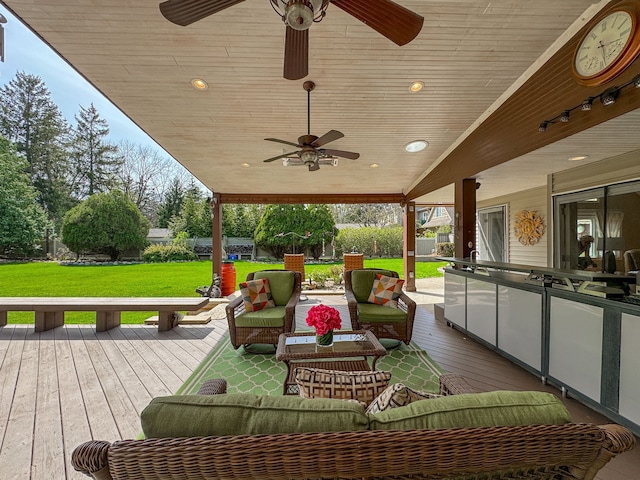 wooden terrace featuring a fenced backyard, a ceiling fan, a yard, and an outdoor living space