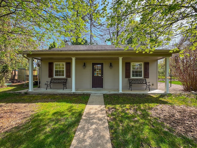 bungalow-style house featuring a front lawn, fence, and covered porch