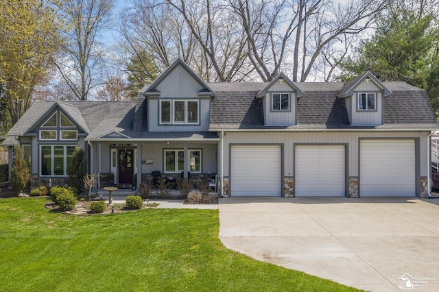 view of front of house featuring a porch, driveway, stone siding, a front yard, and an attached garage