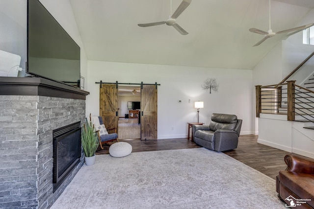 living area with ceiling fan, stairway, wood finished floors, and a barn door