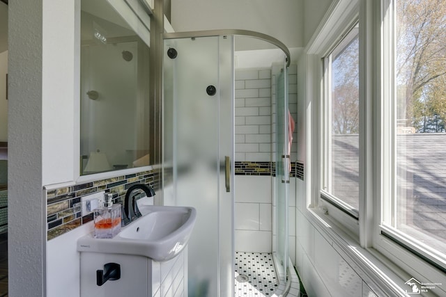 bathroom with tasteful backsplash, vanity, and a stall shower