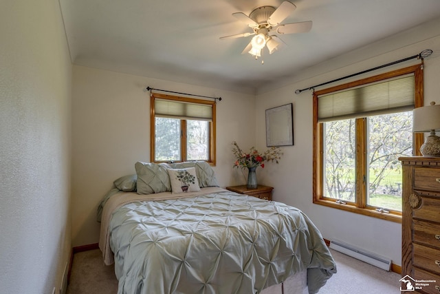 carpeted bedroom with baseboard heating, baseboards, ceiling fan, and multiple windows