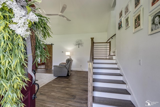 staircase featuring baseboards, wood finished floors, and ceiling fan