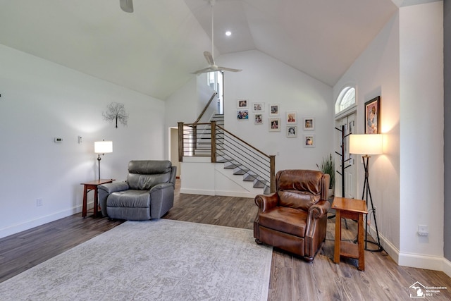 living area with ceiling fan, stairway, wood finished floors, and lofted ceiling