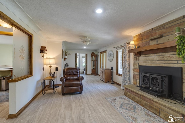 living room with recessed lighting, baseboards, light wood-type flooring, a ceiling fan, and a textured ceiling