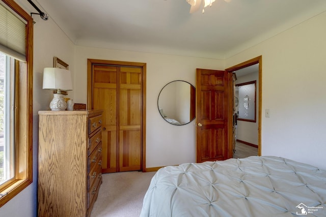 bedroom featuring light colored carpet and baseboards