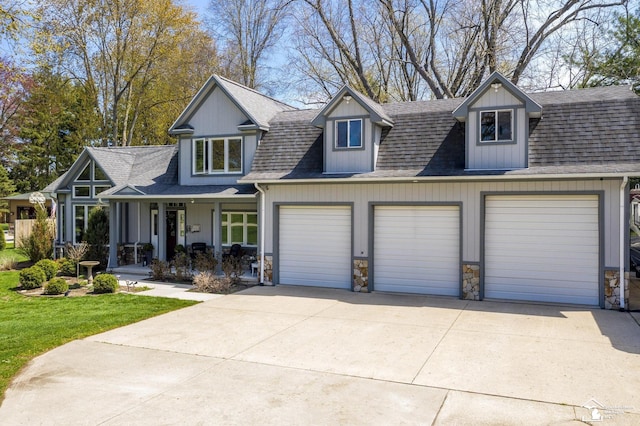 view of front of home with concrete driveway, stone siding, a shingled roof, a porch, and a garage