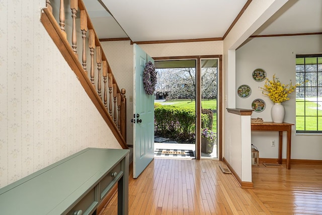 entryway featuring baseboards, light wood finished floors, wallpapered walls, and stairs