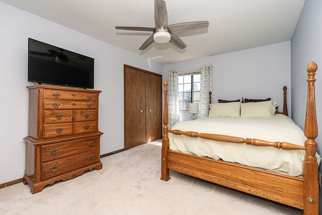 bedroom featuring ceiling fan, light colored carpet, baseboards, and a closet