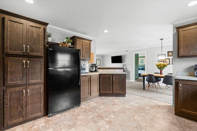 kitchen featuring recessed lighting, crown molding, a peninsula, light countertops, and freestanding refrigerator