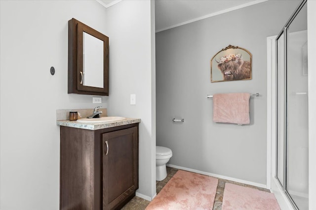 bathroom with a shower stall, vanity, crown molding, toilet, and baseboards