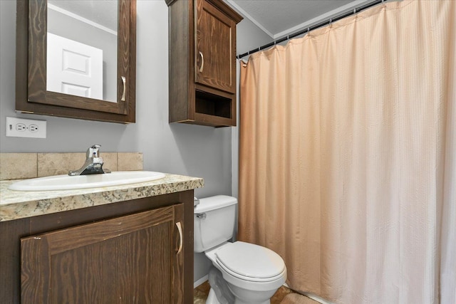 bathroom with toilet, crown molding, and vanity
