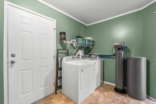 laundry room with stone finish flooring, a textured ceiling, washing machine and clothes dryer, and laundry area