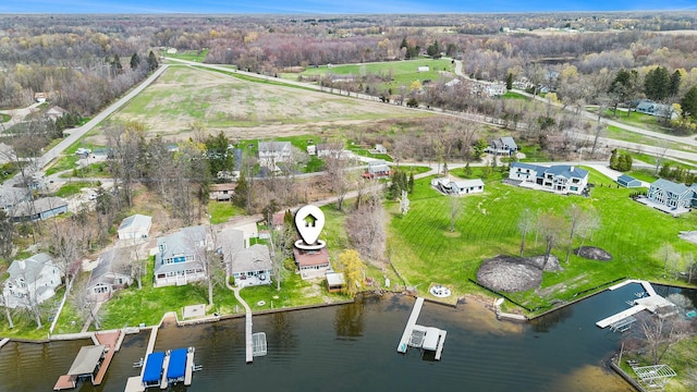 birds eye view of property featuring a forest view and a water view